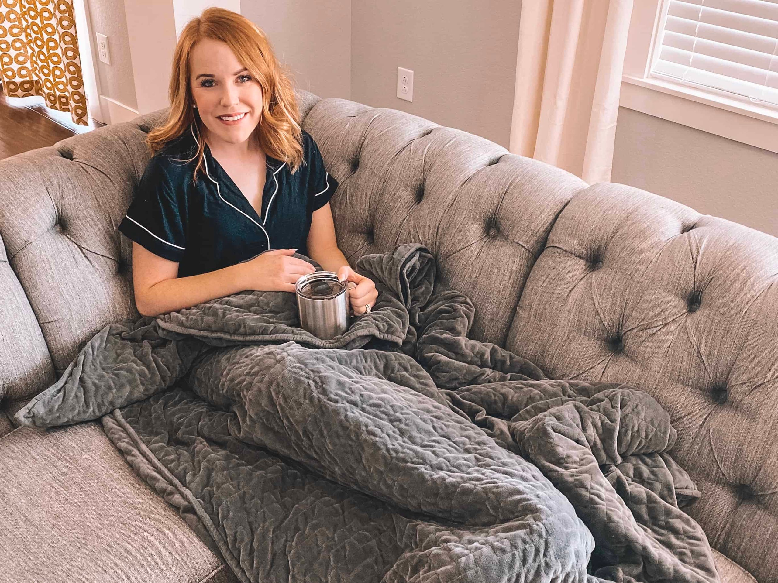 a woman sitting on a couch with a cup of coffee