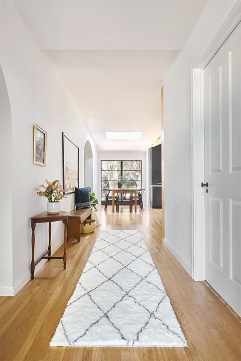 a hallway with a rug and a table