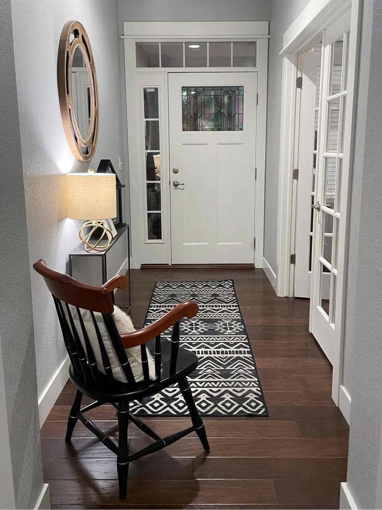 a hallway with a chair and a rug