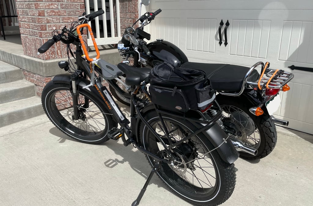 the radrover5 (in front) with the urider kids seat and a triumph motorcycle in the back