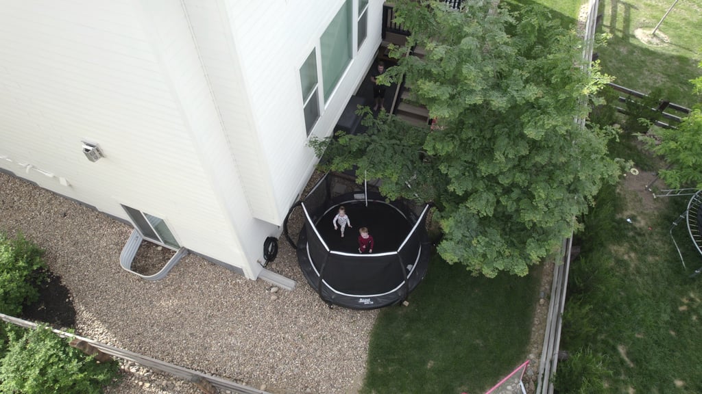 a kids on a trampoline in a yard