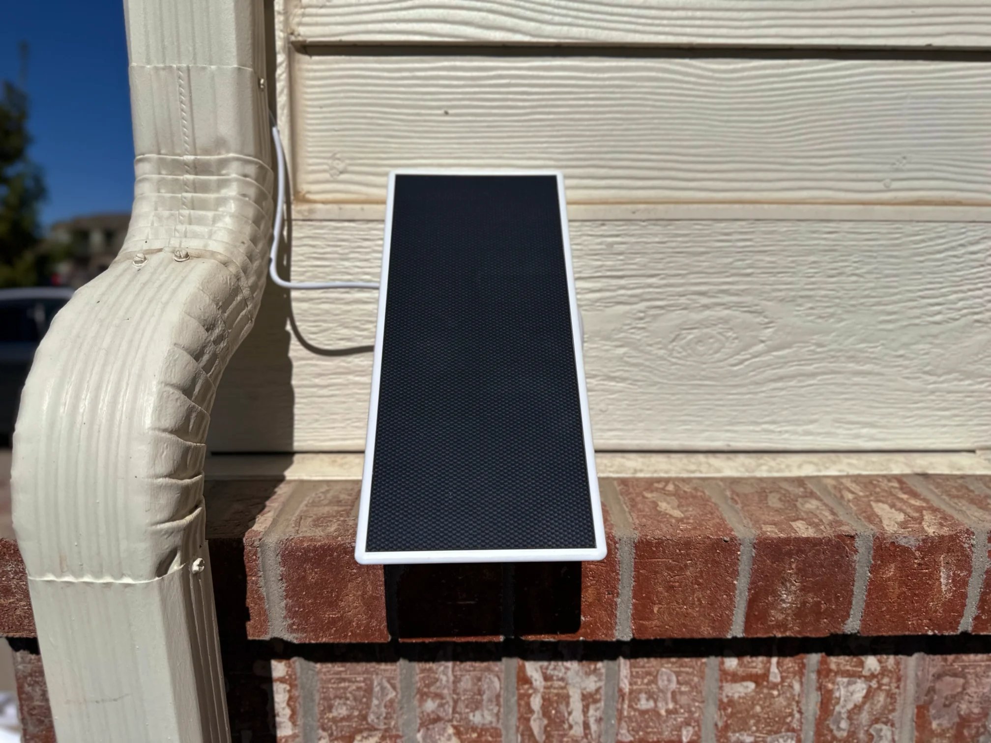 a black rectangular object on a brick wall