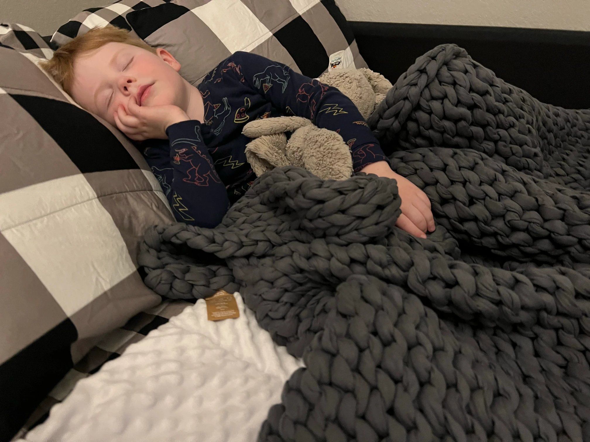 a child sleeping on a bed with a blanket