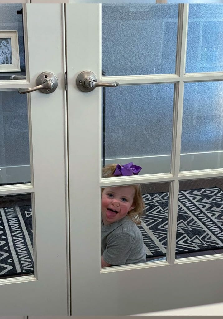 a child peeking through a glass door